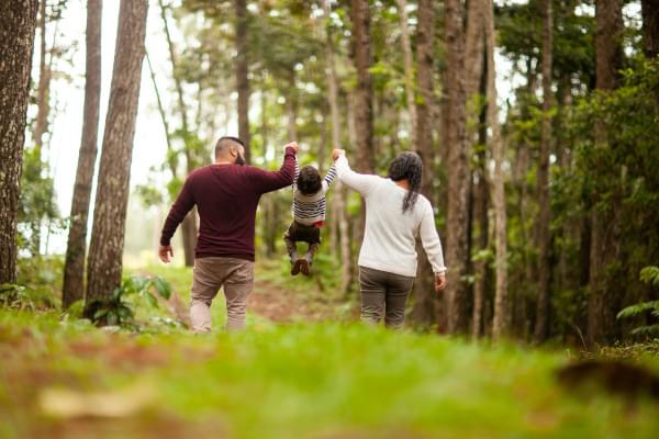 Parents se promenant en forêt avec leur enfant