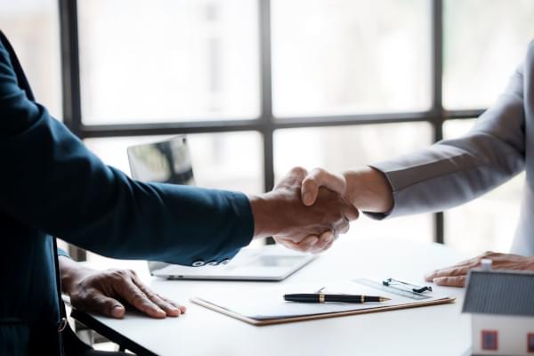 Poignée de main professionnelle au dessus d'un bureau